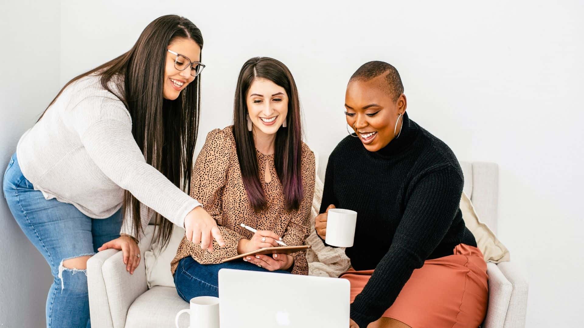 three business woman looking at a laptop